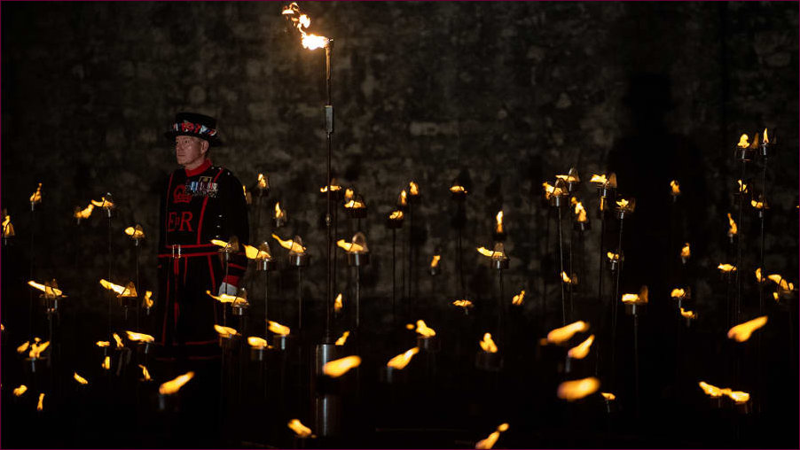 Lone Beefeater amongst a dea of flame in the Tower Moat