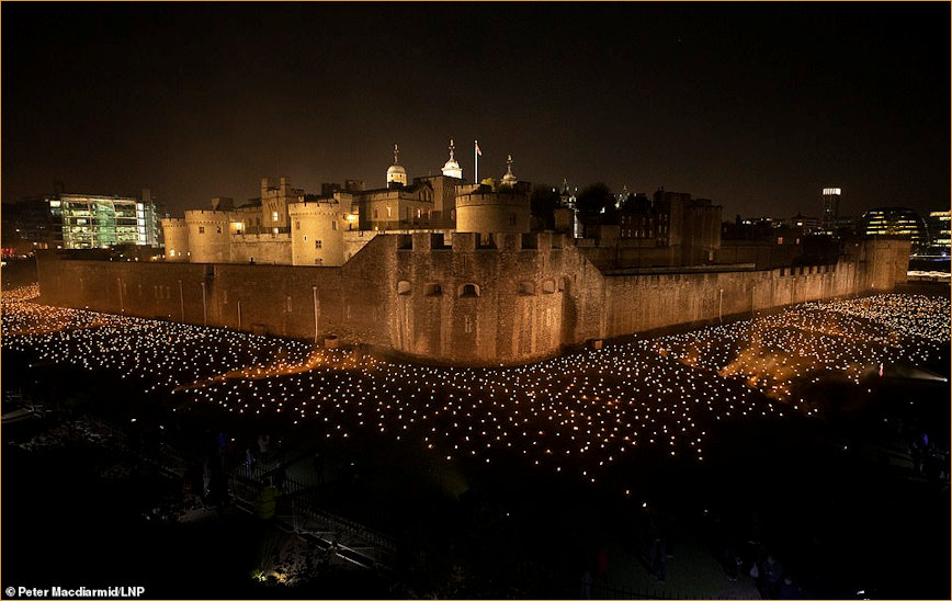 Panorama of illuminated Tower of London and moat filled with torches