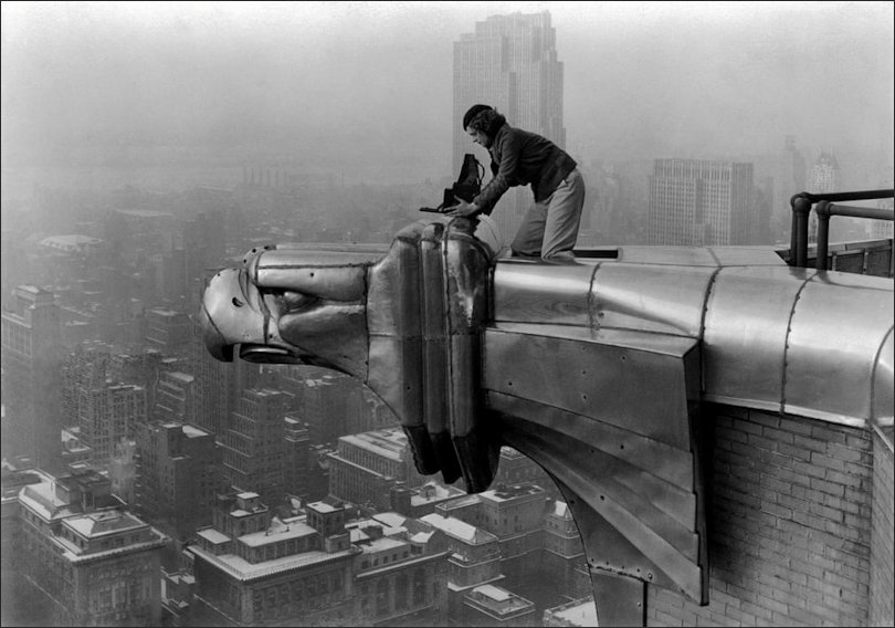 American photographer and journalist Margaret Bourke-White perches on an eagle head gargoyle at the top of the Chrysler building