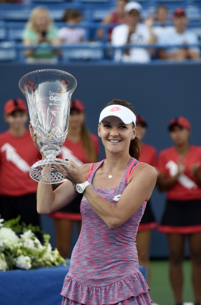 A smiling Aga holds up New Haven trophy