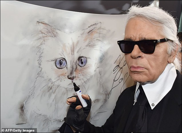 Lagerfeld poses next to a painting of  Choupette